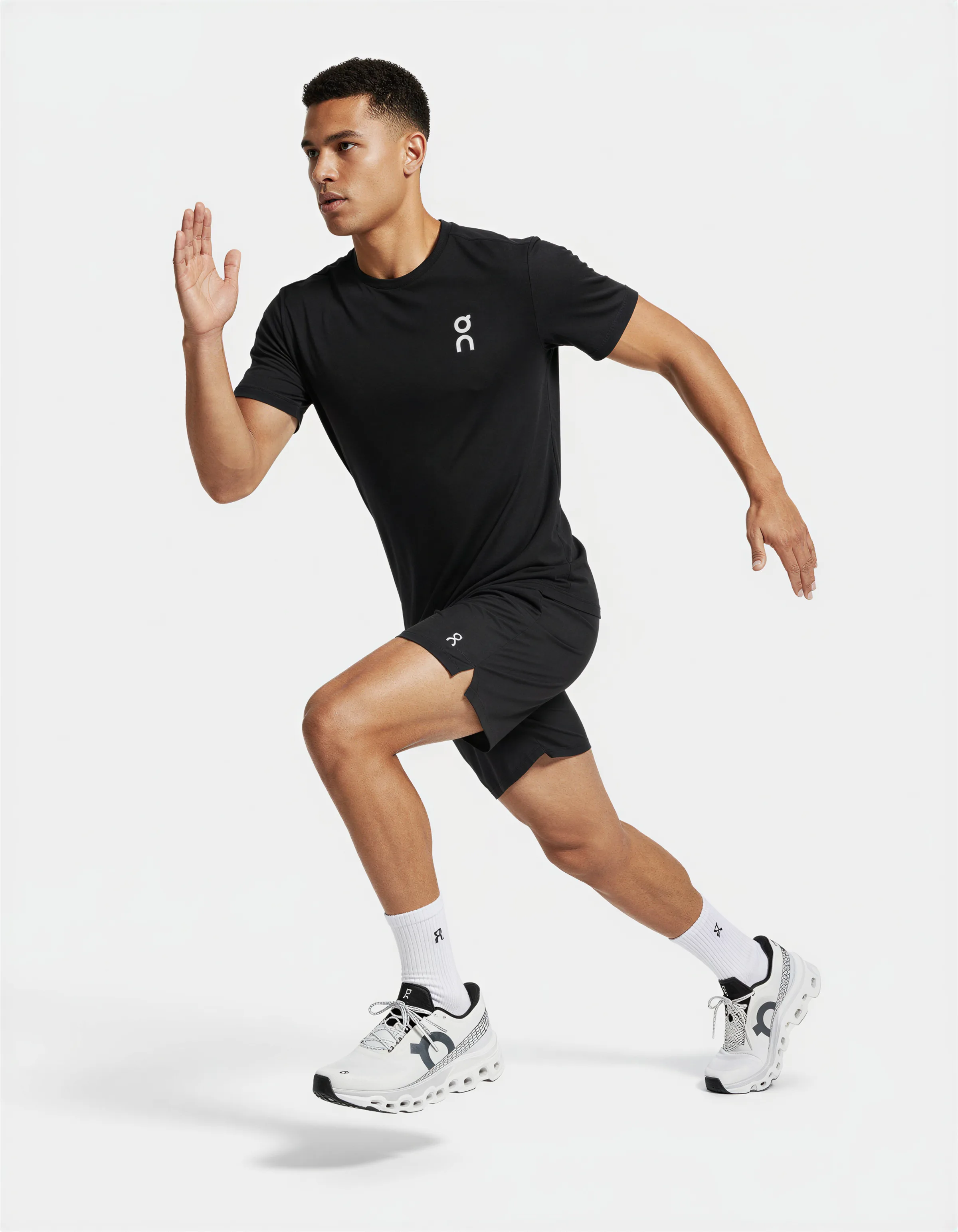 AI image of a man mid-stride in a black On T-shirt, black shorts and white running shoes on a white background. On AI Concept.