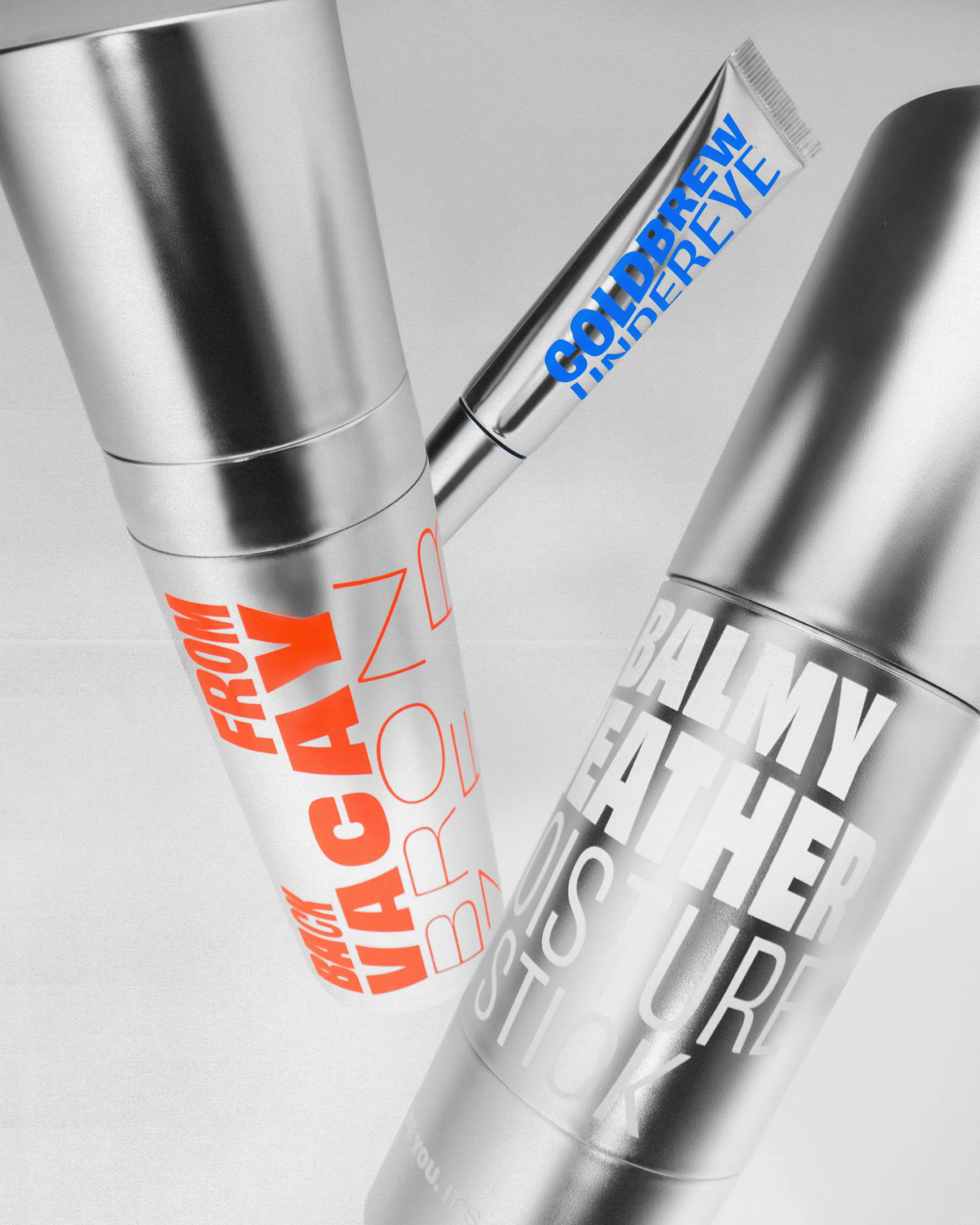 Silver skincare tubes with orange, blue and white type, including Coldbrew Undereye and a moisture stick, for Good Weird.