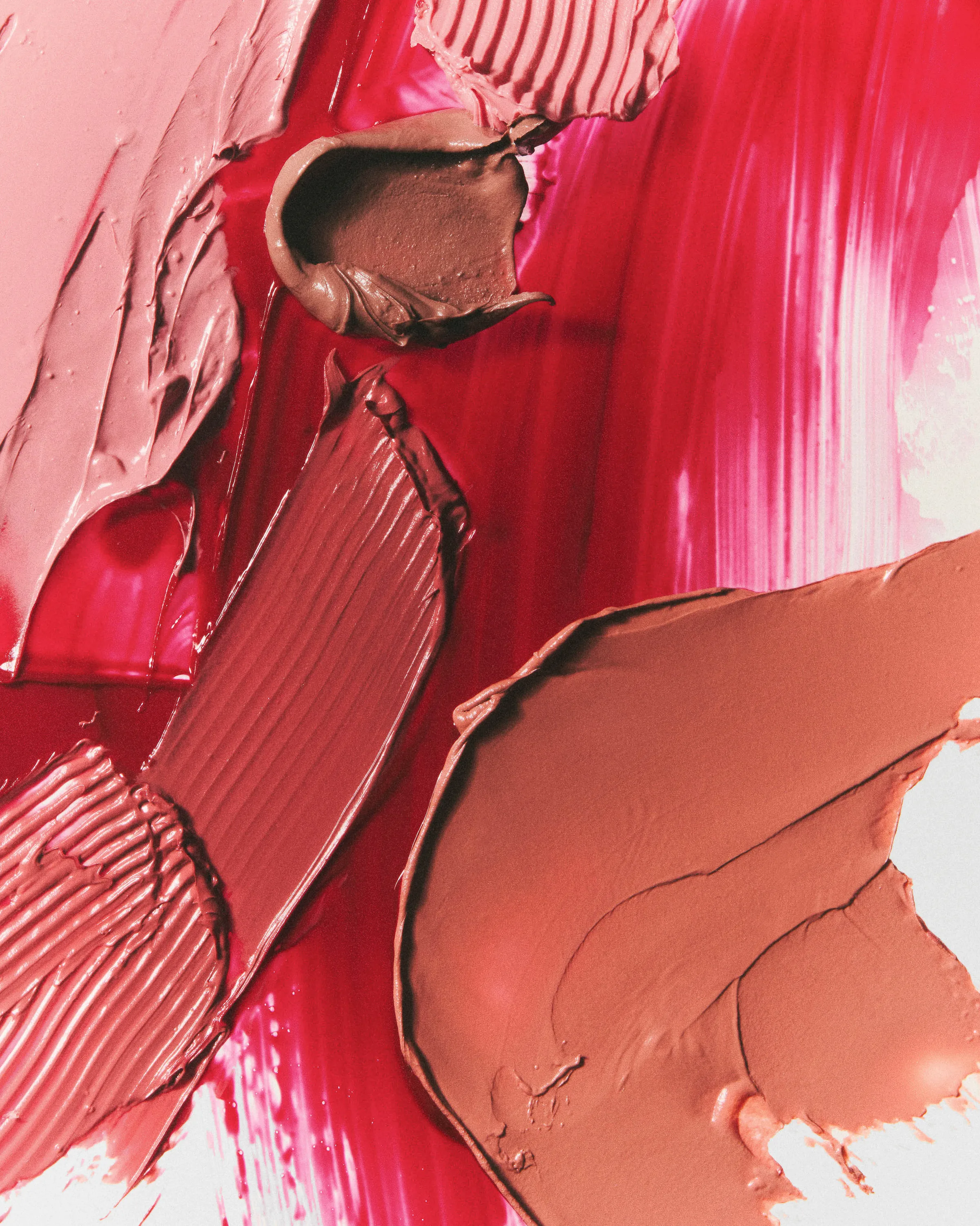 Smeared lipstick swatches in pink, nude and berry red with brushed and sculpted textures, for Kylie Cosmetics.