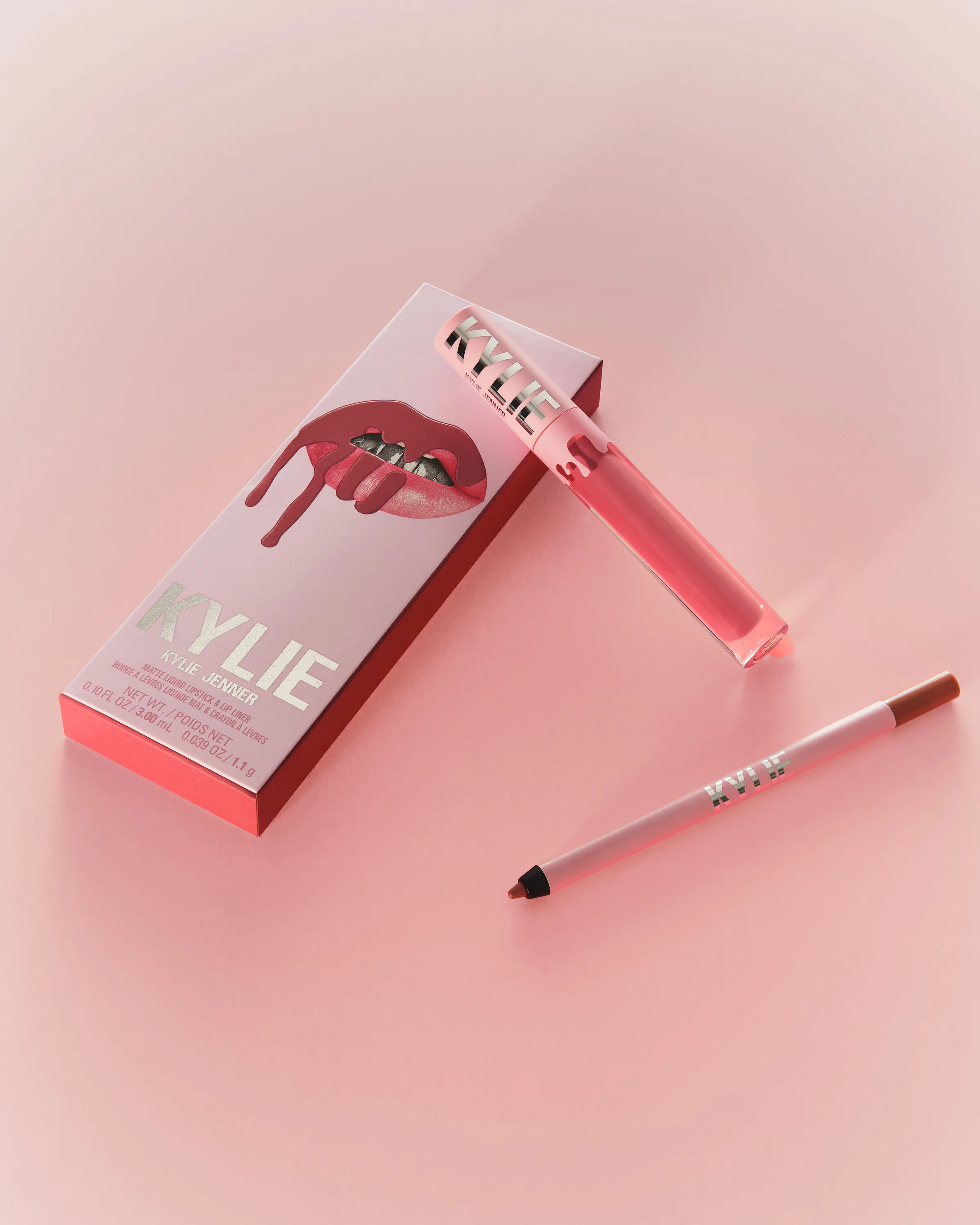 Pink lip kit box with liquid lipstick and lip liner on a soft pink background, for Kylie Cosmetics.