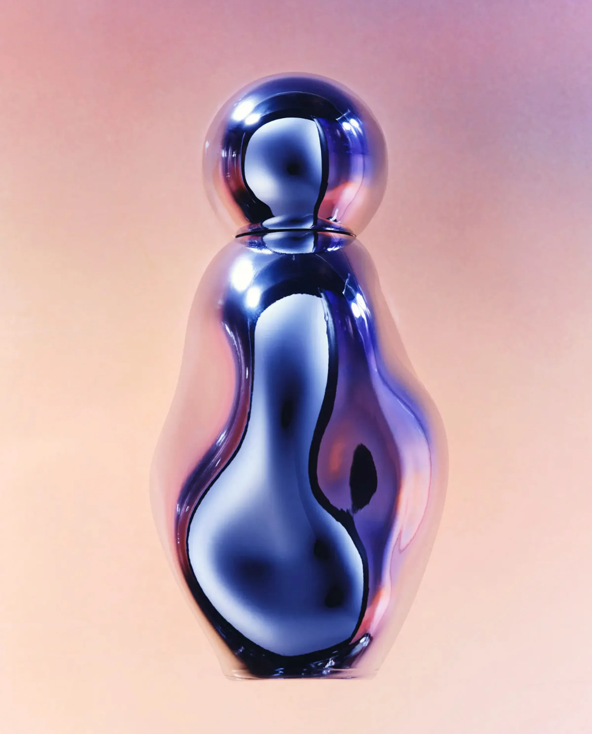 Curvy chrome perfume bottle with round cap reflecting blue light against a peach-to-pink gradient, for Kylie Cosmetics.