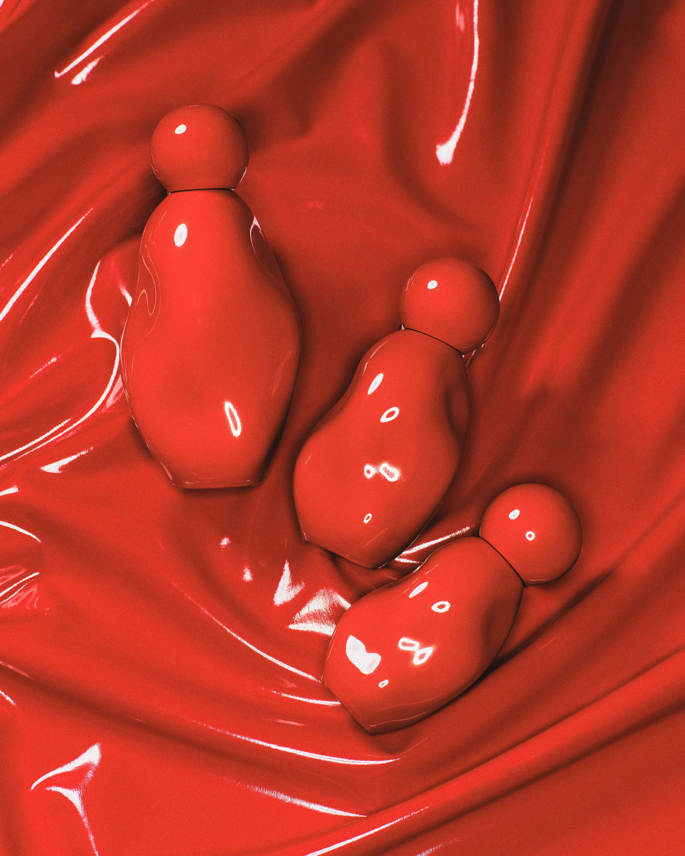 Three glossy red sculpted perfume bottles nestled in rippled red vinyl, for Kylie Cosmetics.