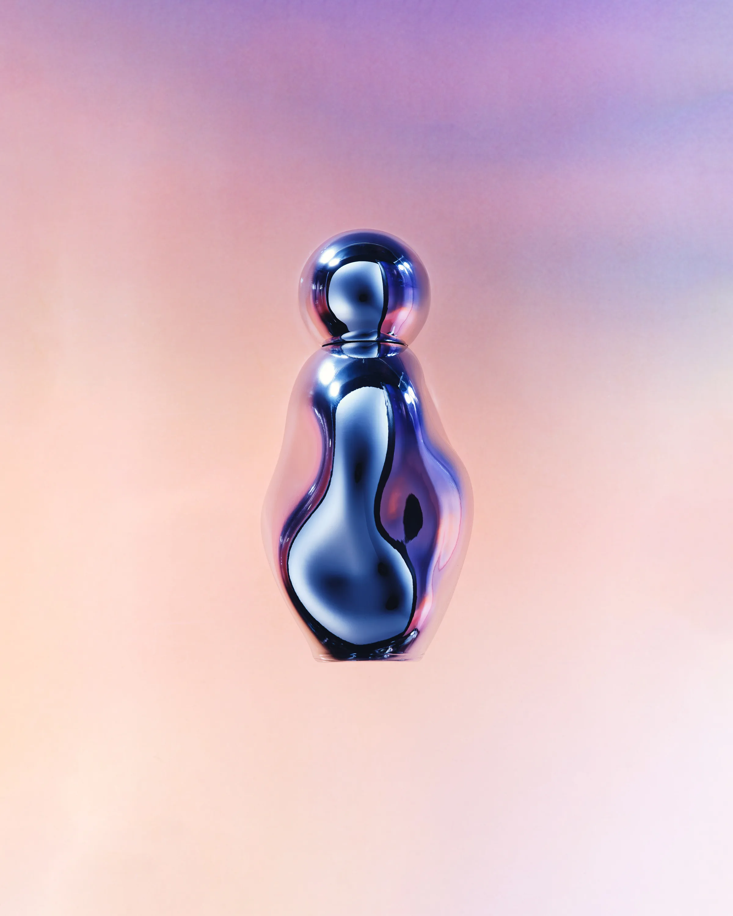 Organic-shaped chrome perfume bottle floating against a soft pink and lilac gradient, for Kylie Cosmetics.