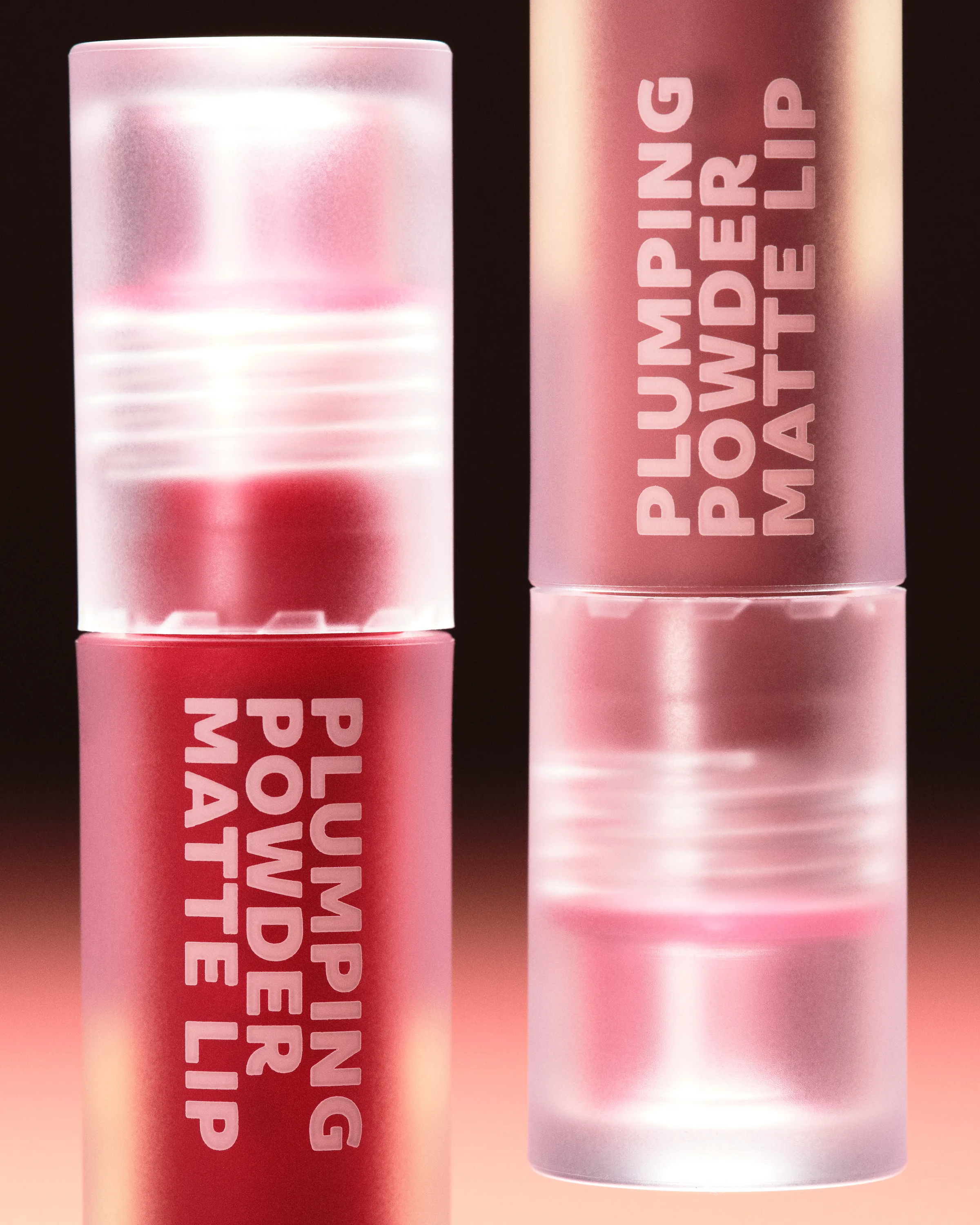 Two frosted Plumping Powder Matte Lip tubes in red and pink, inverted against a dark-to-peach gradient, for Kylie Cosmetics.