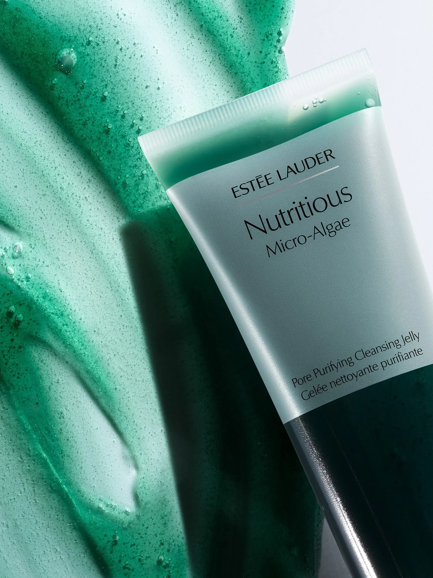 Nutritious Micro-Algae cleansing jelly tube resting on a swipe of green gel texture, for Estée Lauder.