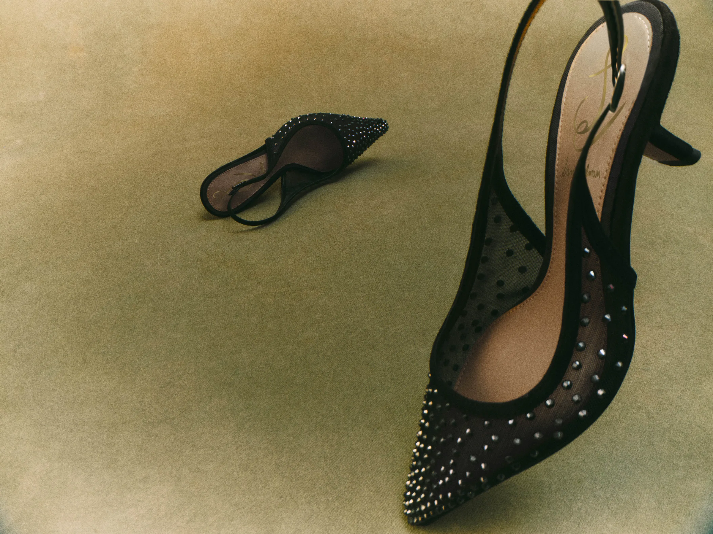 Black mesh slingback heels with crystal studs and pointed toes on an olive green backdrop, for Sam Edelman.