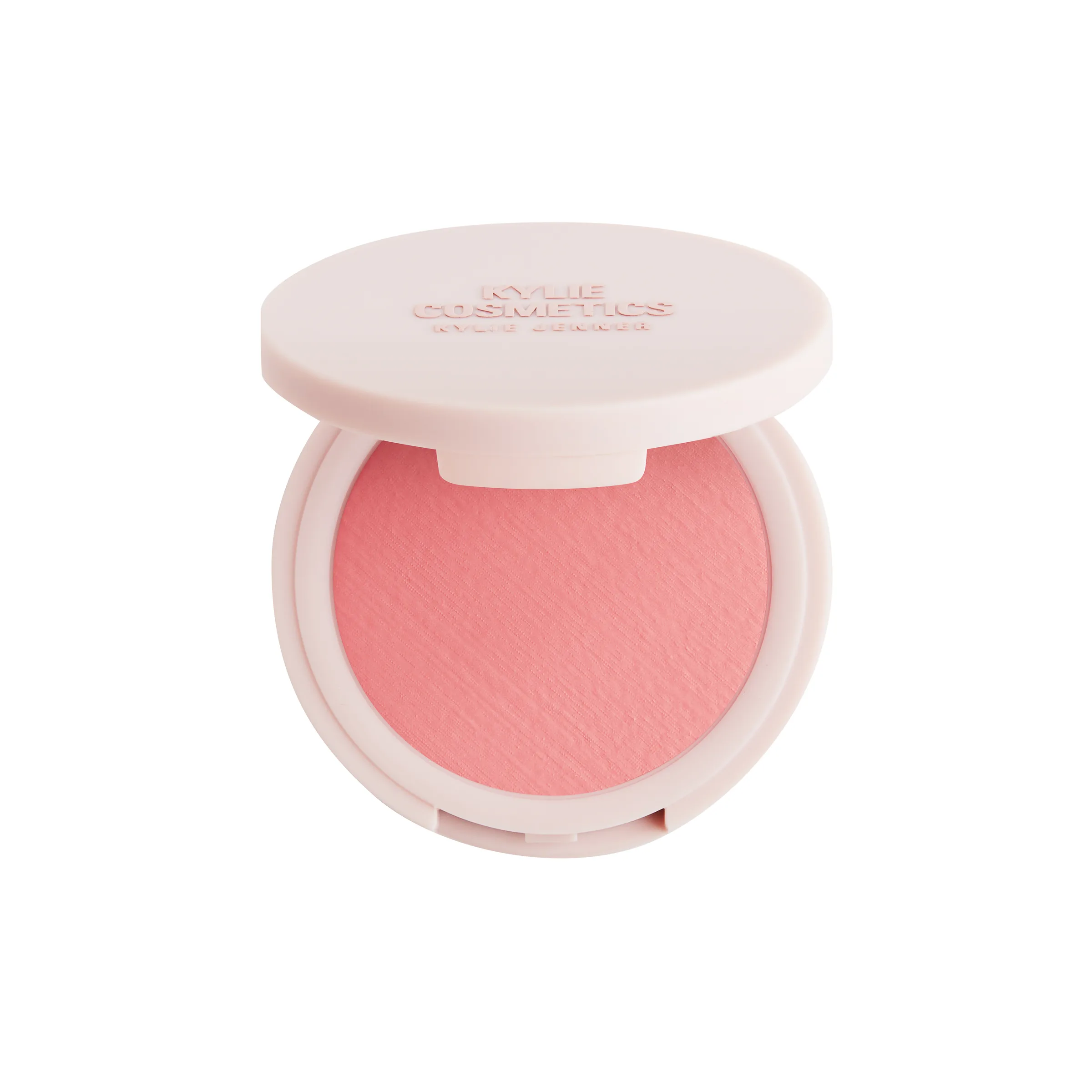 Open pale pink compact of coral pink powder blush with embossed lid on a white background, for Kylie Cosmetics.