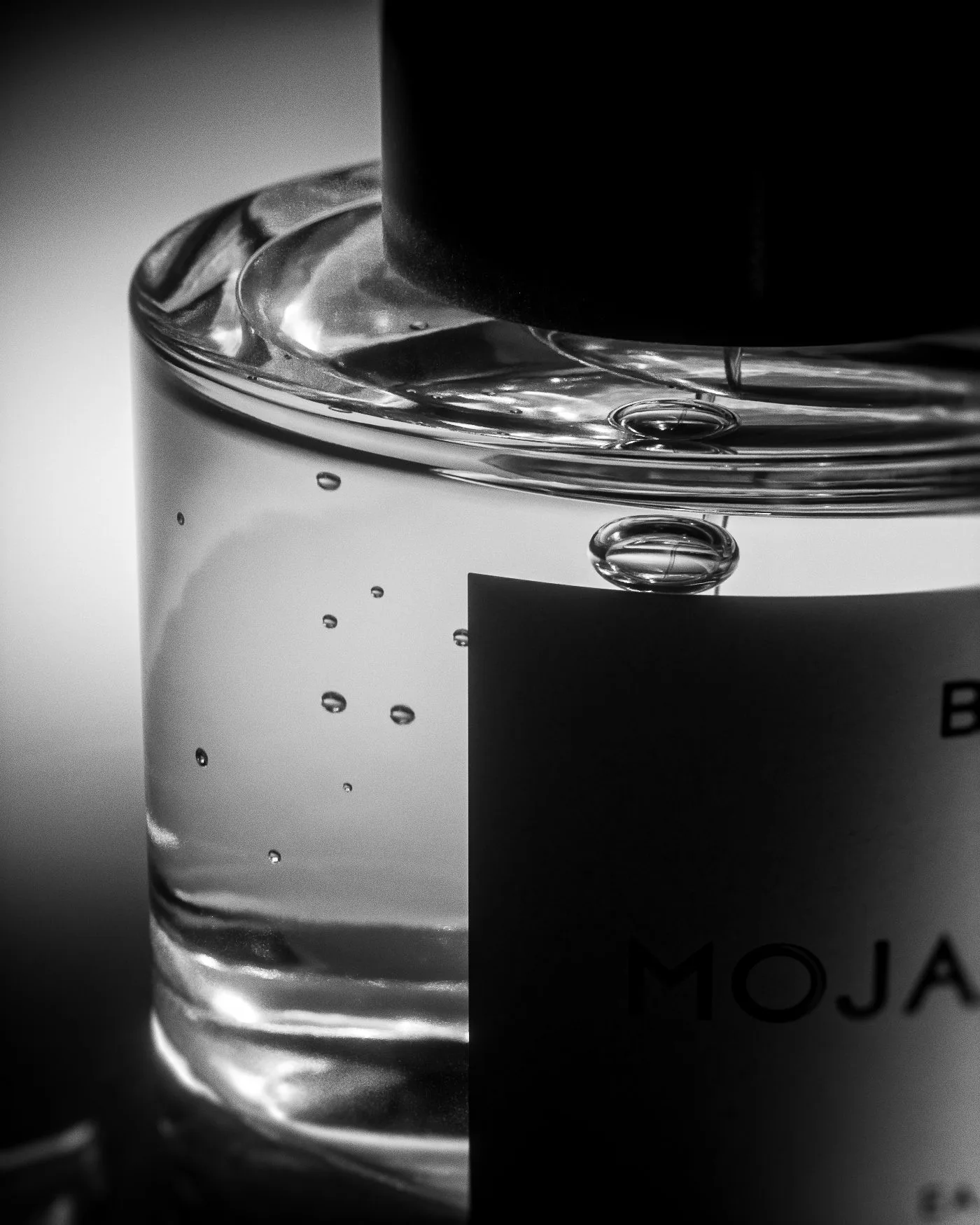 CGI render of a Mojave Ghost perfume bottle in black and white, close on bubbles in the glass, for Byredo.