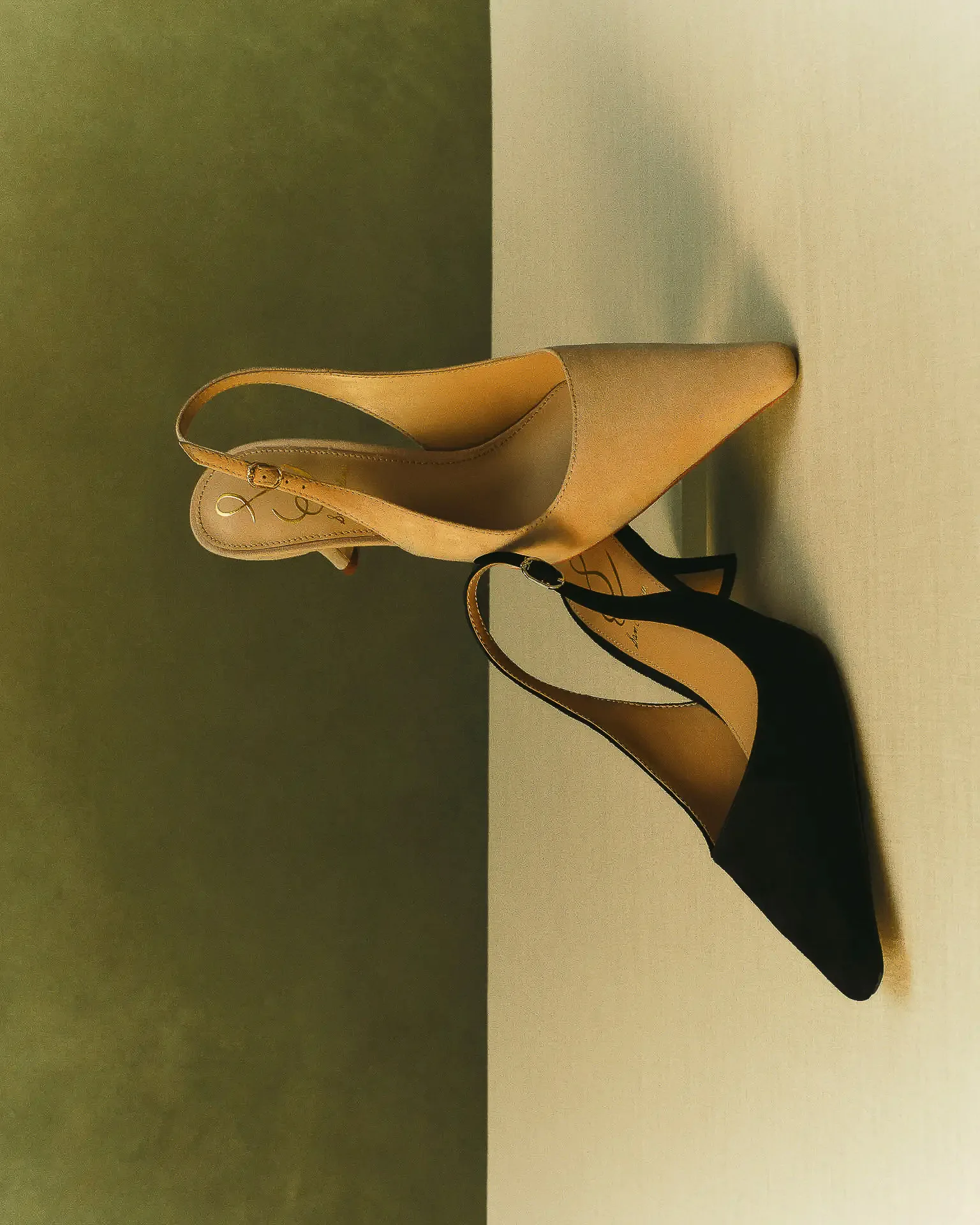 Tan and black pointed slingback heels on a split olive and cream backdrop, shot sideways, for Sam Edelman.