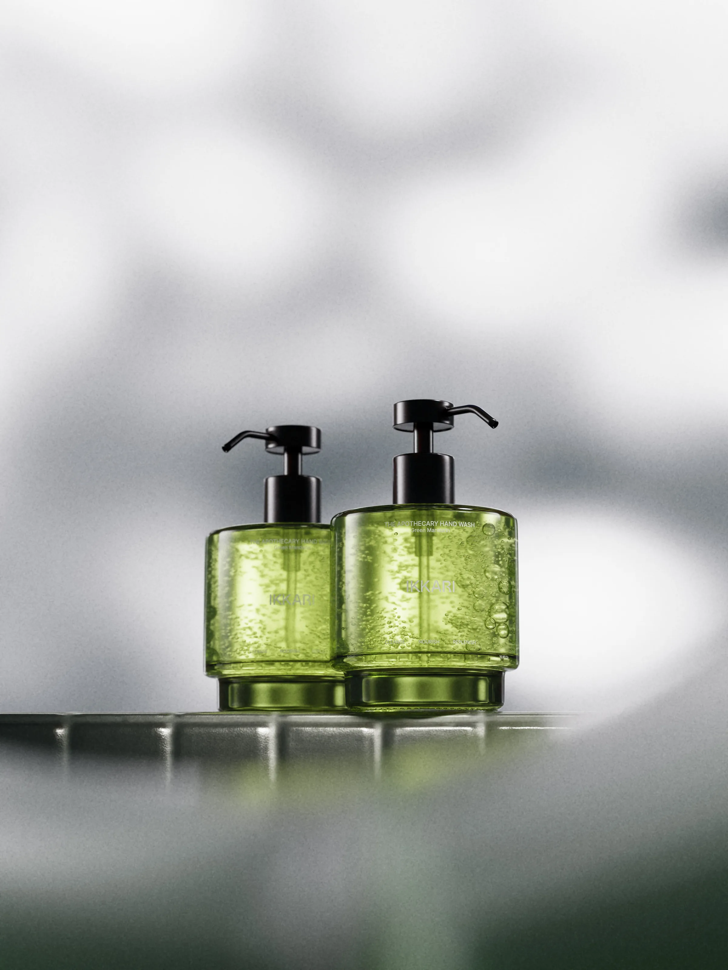 CGI render of two green glass hand soap pump bottles on a glass tile ledge against a blurred grey backdrop, for Ikkari.