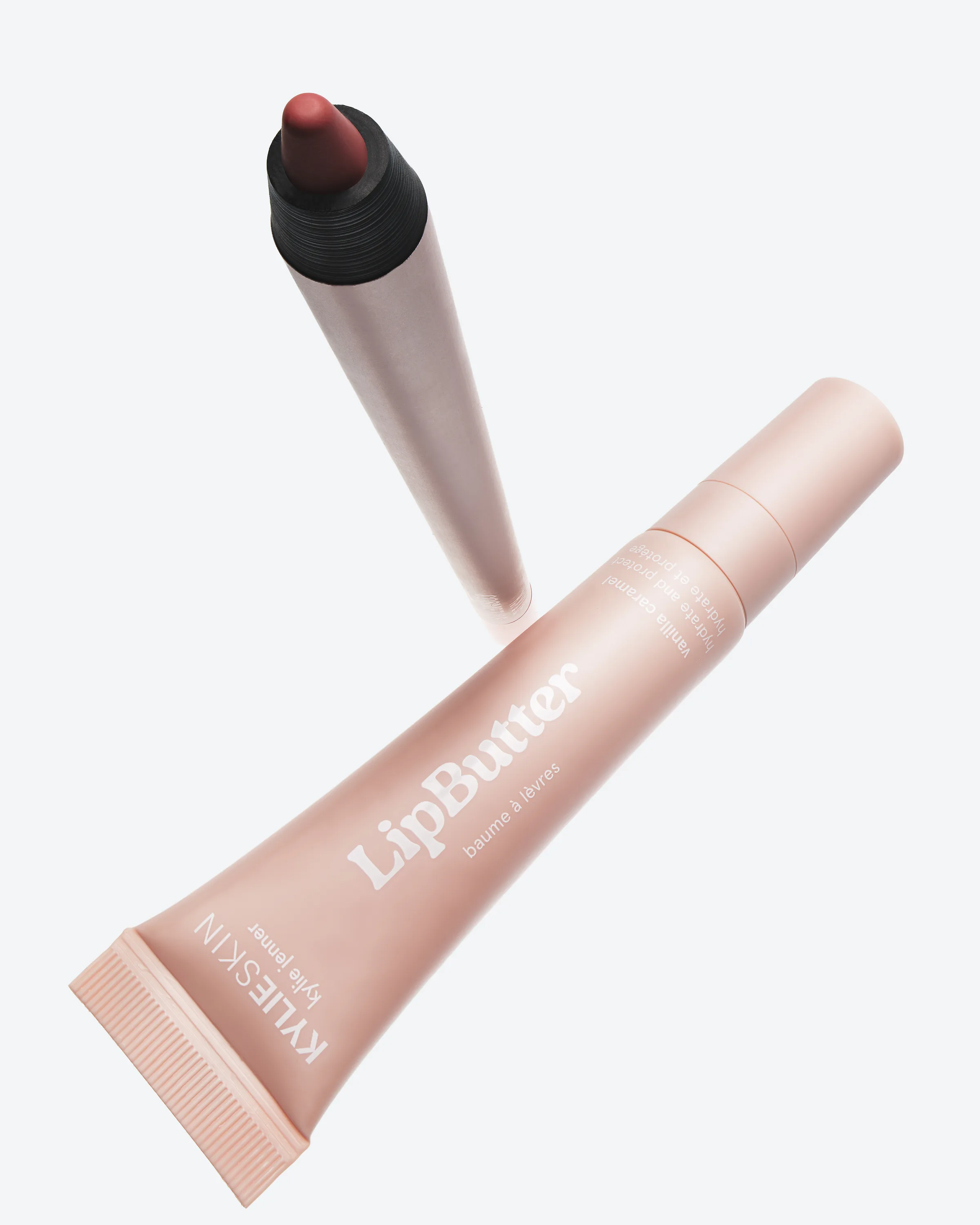 Risky Rose plumping lip liner floating above a pink Vanilla Lip Butter tube on a pale grey background, for Kylie Cosmetics.